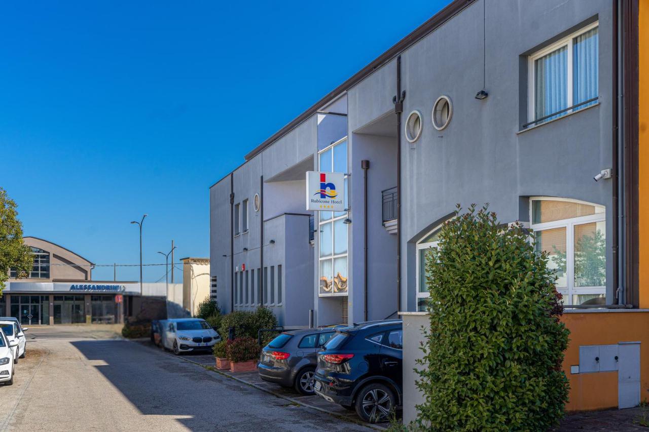 een gebouw met auto's geparkeerd op een parkeerplaats bij Hotel Rubicone in Savignano sul Rubicone