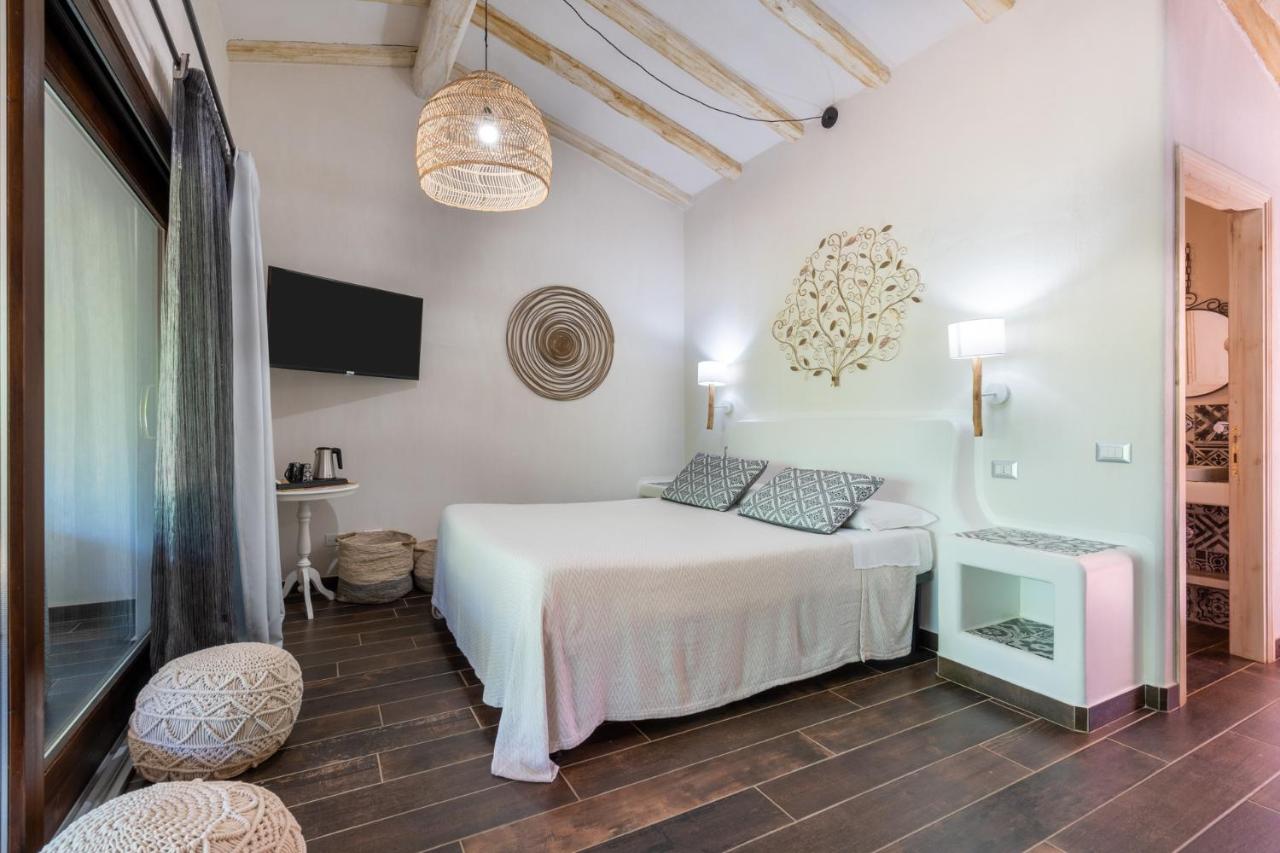 een witte slaapkamer met een bed en twee stoelen bij Felix Hotels - Galanias Hotel & Retreat in Bari Sardo +81 foto's