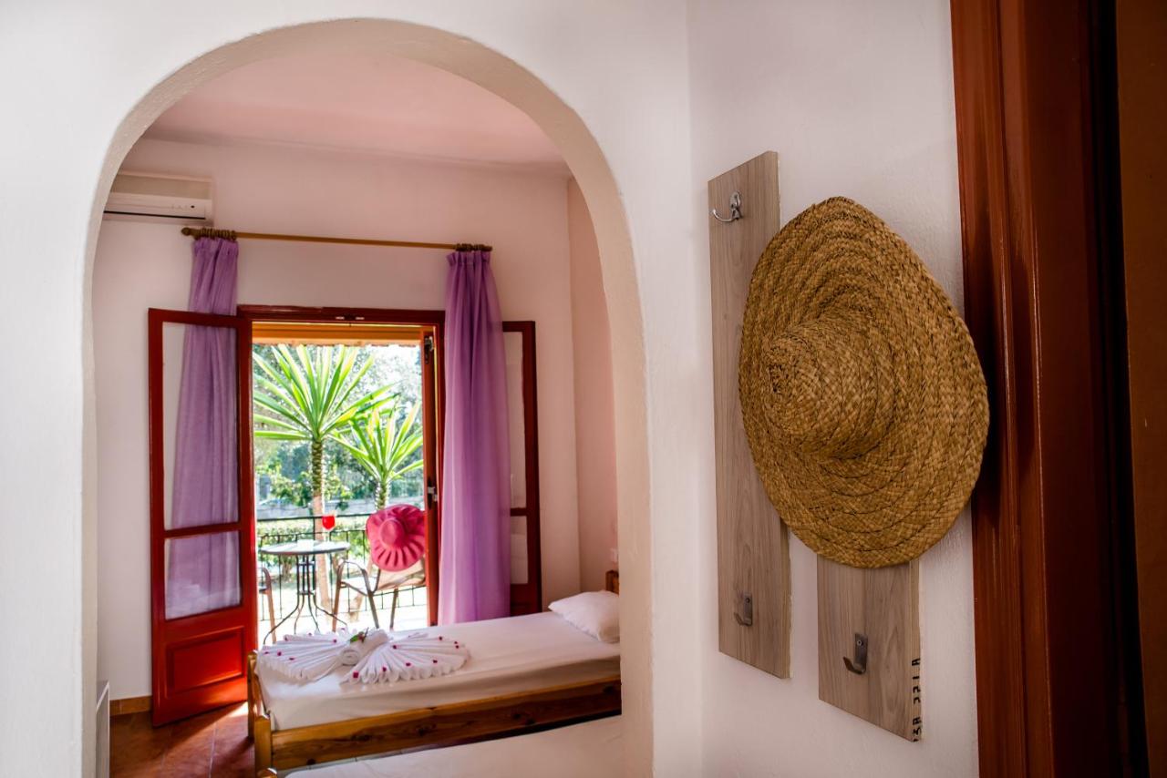 een slaapkamer met een bed en een raam met paarse gordijnen bij Kalypso studio Resorts in Kavos