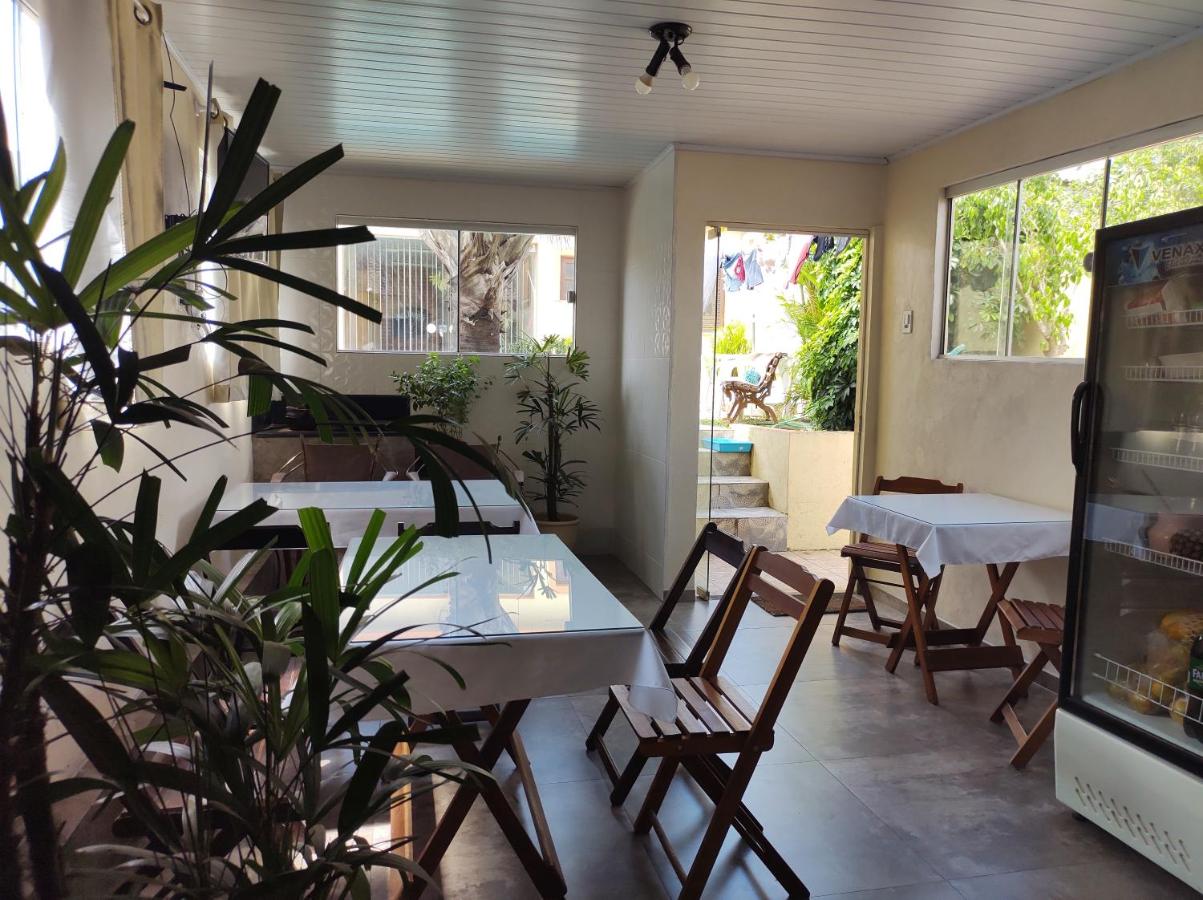 een eetkamer met een tafel en stoelen en een plant bij Apart São Gabriel in São Gabriel