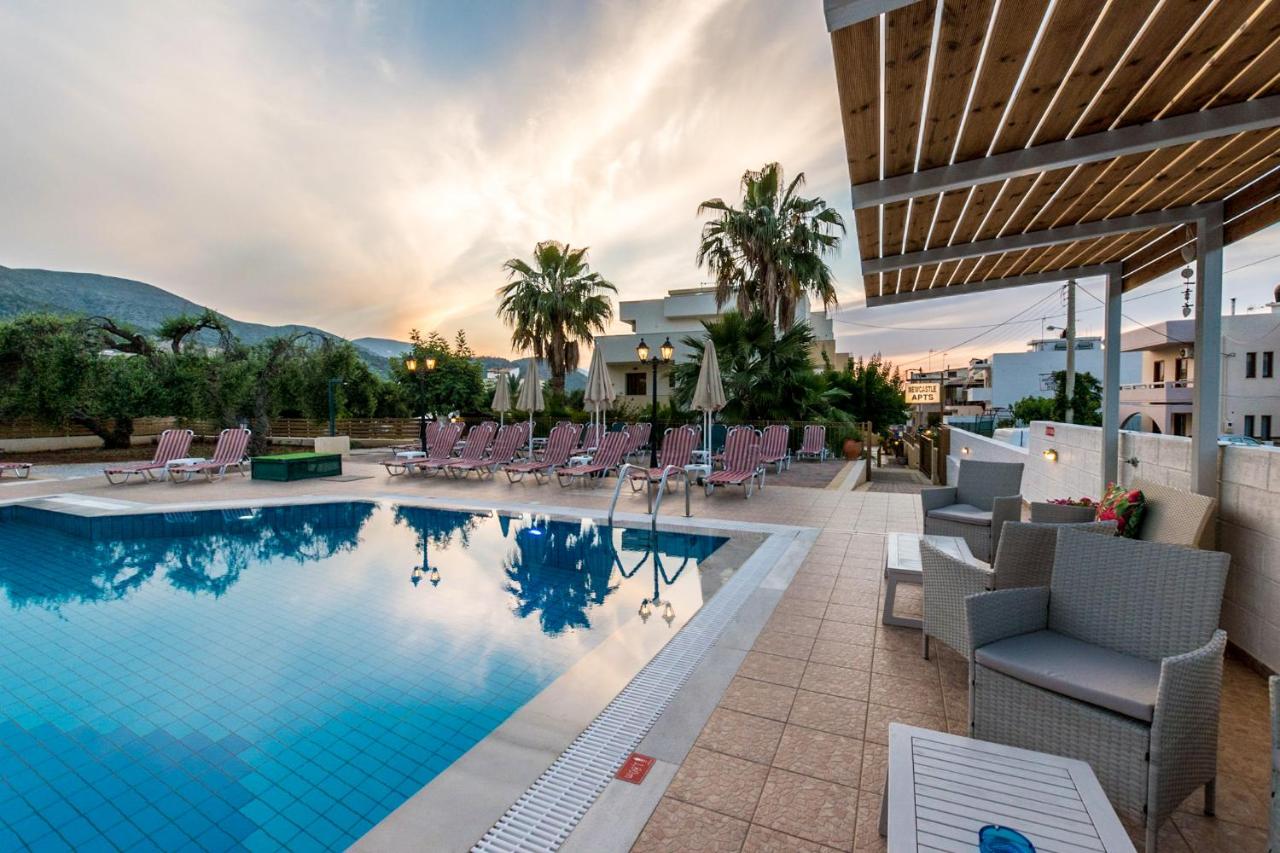 een zwembad bij een hotel met ligstoelen bij Newcastle Studios in Malia