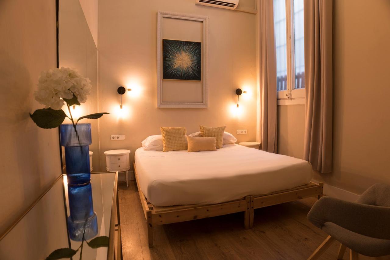 een slaapkamer met een bed en een vaas met bloemen bij Cami Gallery Barcelona in Barcelona