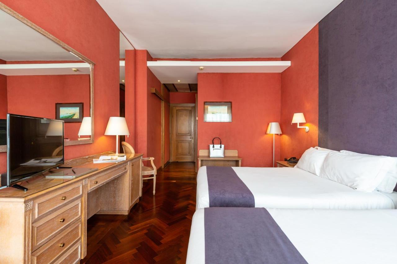 een hotelkamer met een bed en een flatscreen-tv bij Culture Hotel Villa Capodimonte in Napels