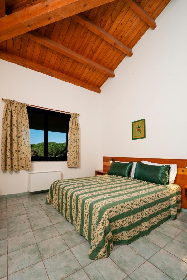 een slaapkamer met een bed en een raam bij Horse Country Resort Congress & Spa - Hotel Castello in Arborea 