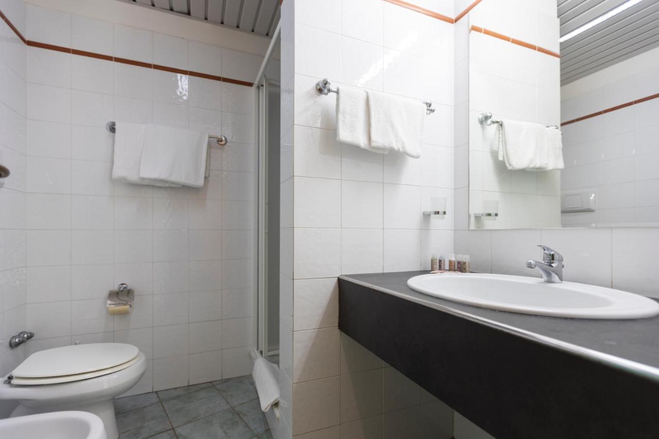 een witte badkamer met een wastafel en een toilet bij Horse Country Resort Congress & Spa - Hotel Castello in Arborea 