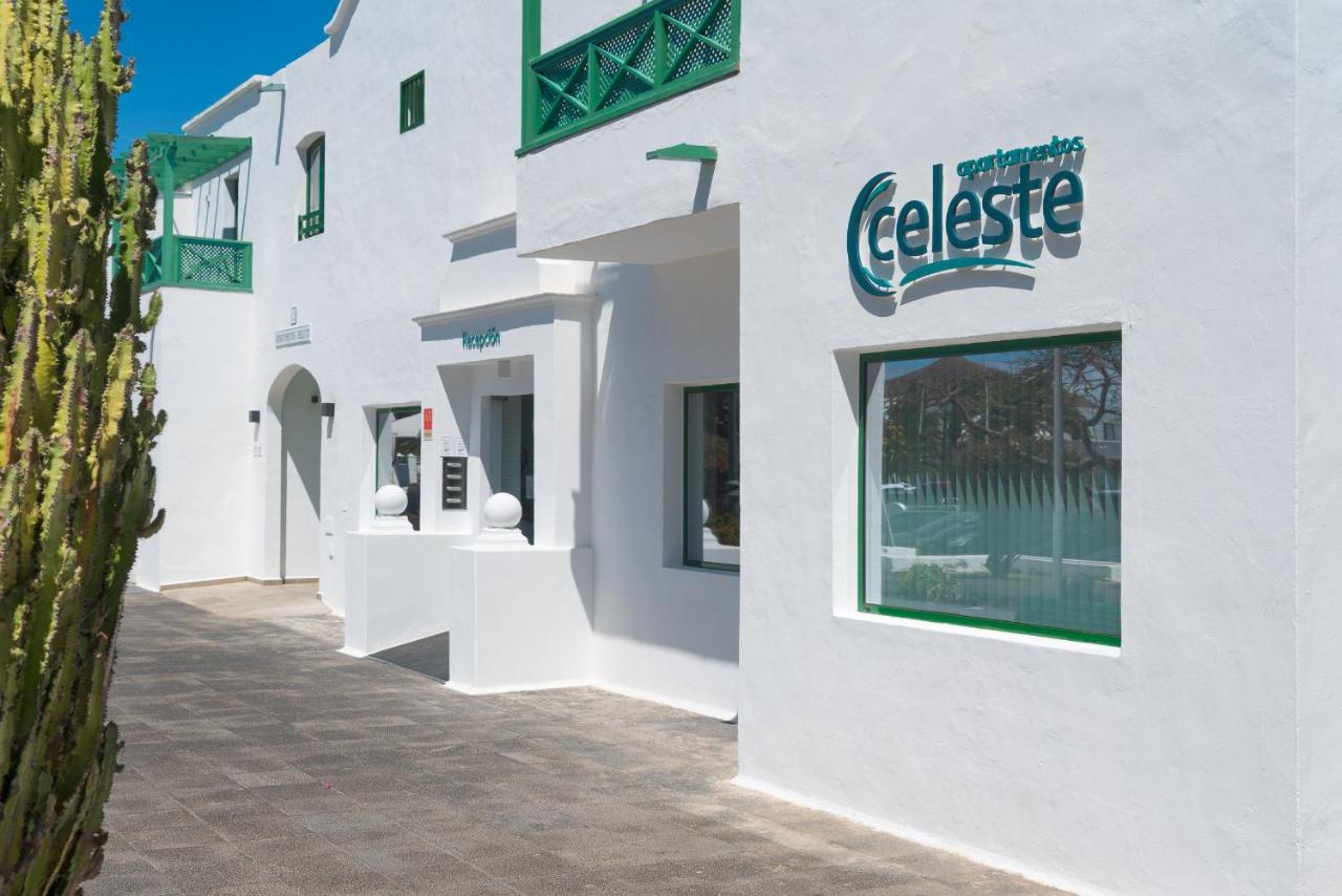 een wit gebouw met een bord aan de zijkant bij Apartamentos Celeste in Costa Teguise