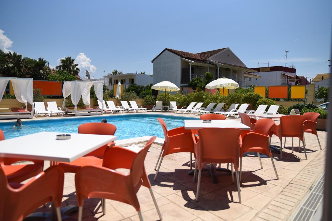 een rij tafels en stoelen naast een zwembad bij Kavos Central Gardens in Kavos