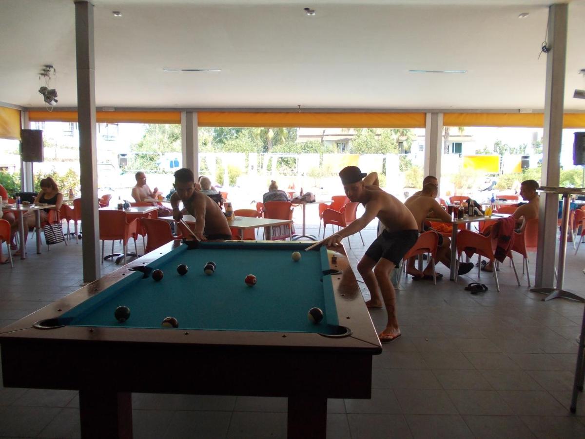 Twee mannen die een potje pool spelen in een restaurant. bij Kavos Central Gardens in Kavos