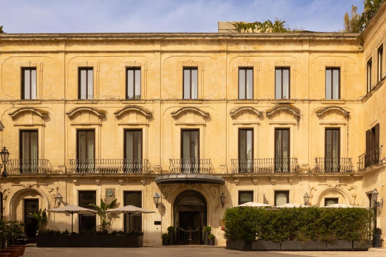 een groot geel gebouw met ramen en balkons bij Patria Palace Lecce - The Leading Hotels of The World in Lecce