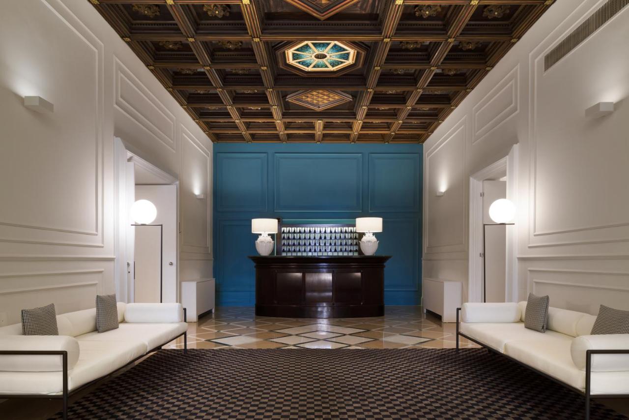 een lobby met twee witte banken en een blauwe muur bij Patria Palace Lecce - The Leading Hotels of The World in Lecce