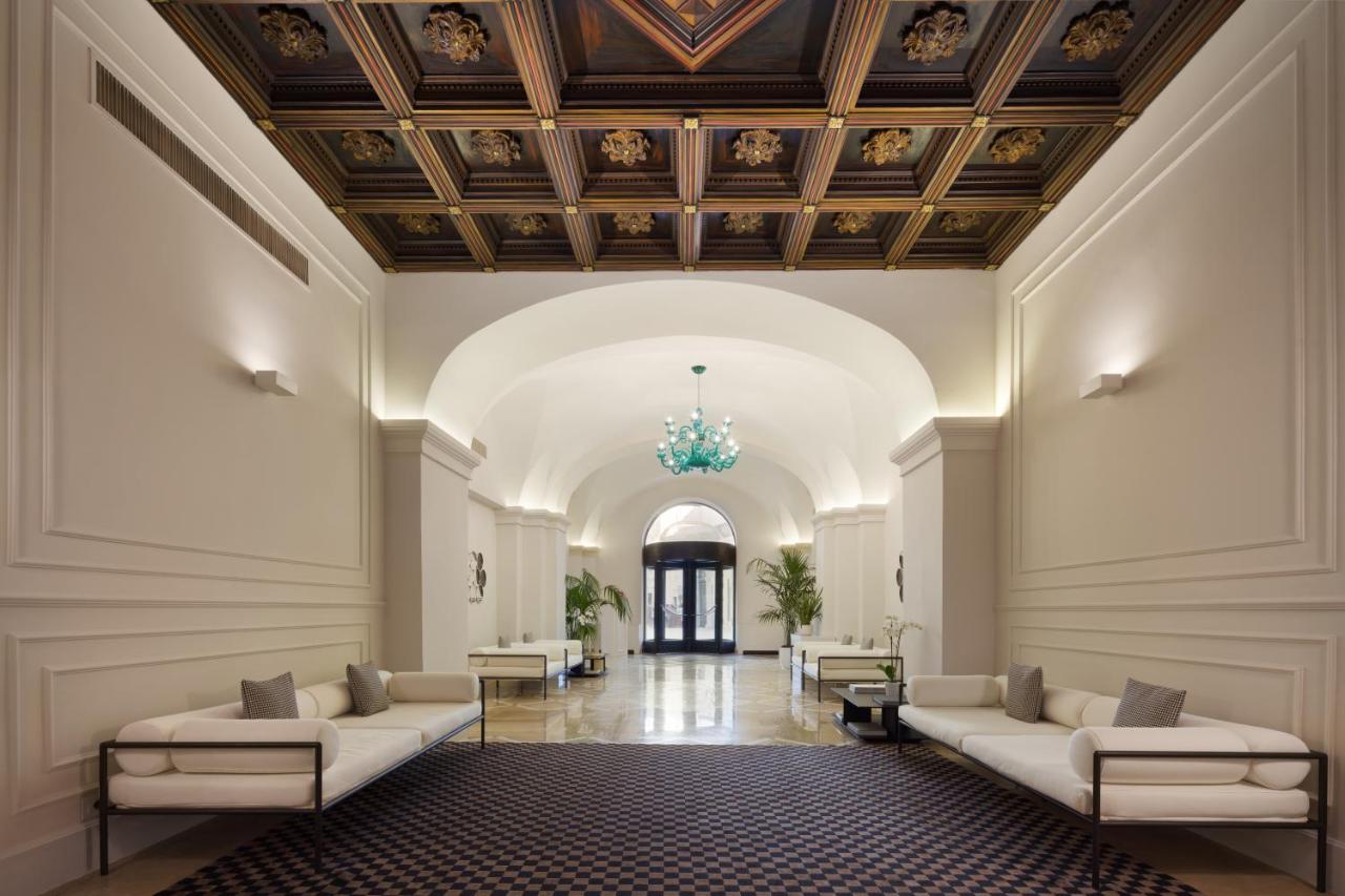 een lobby met banken en een plafond met een kroonluchter bij Patria Palace Lecce - The Leading Hotels of The World in Le