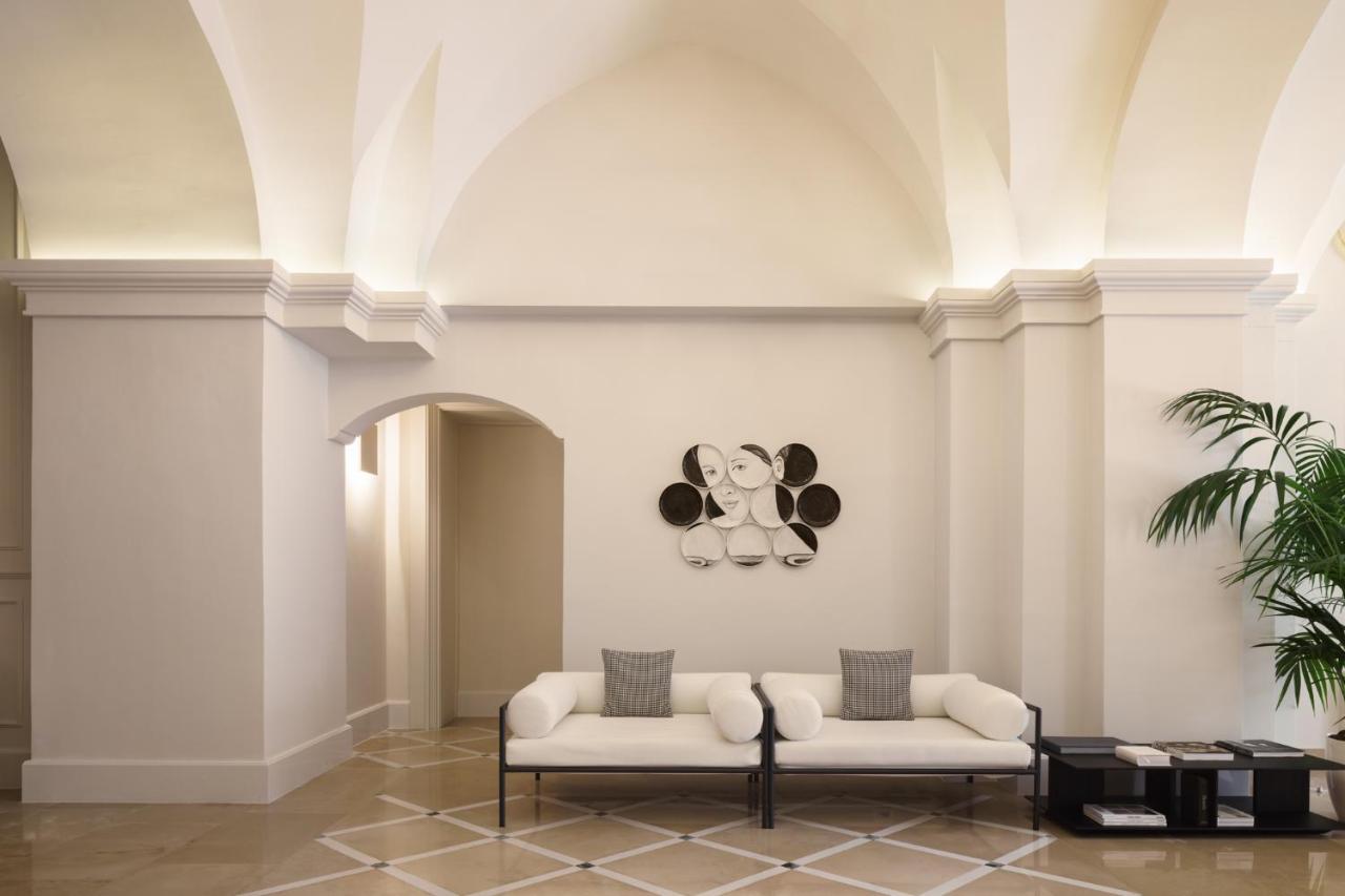 een lobby met twee stoelen en een koala-afbeelding aan de muur bij Patria Palace Lecce - The Leading Hotels of The World