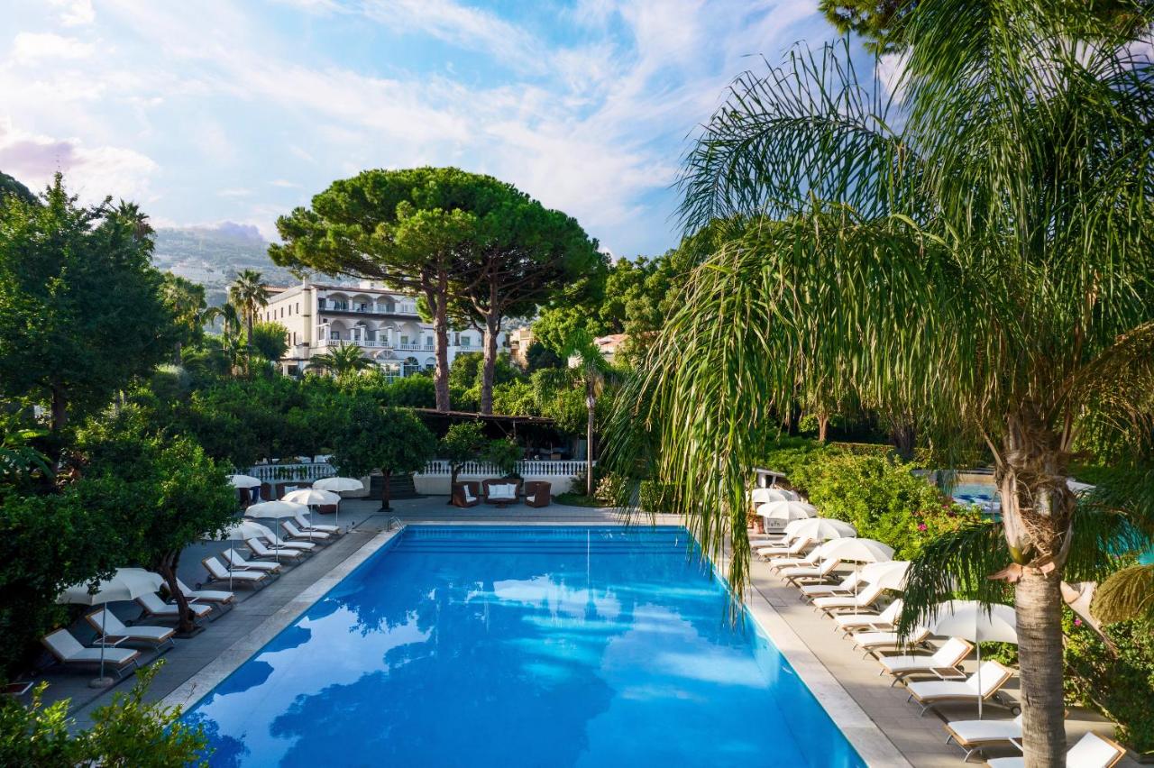 een zwembad met ligstoelen en een resort bij Grand Hotel Cocumella in Sant'Agnello