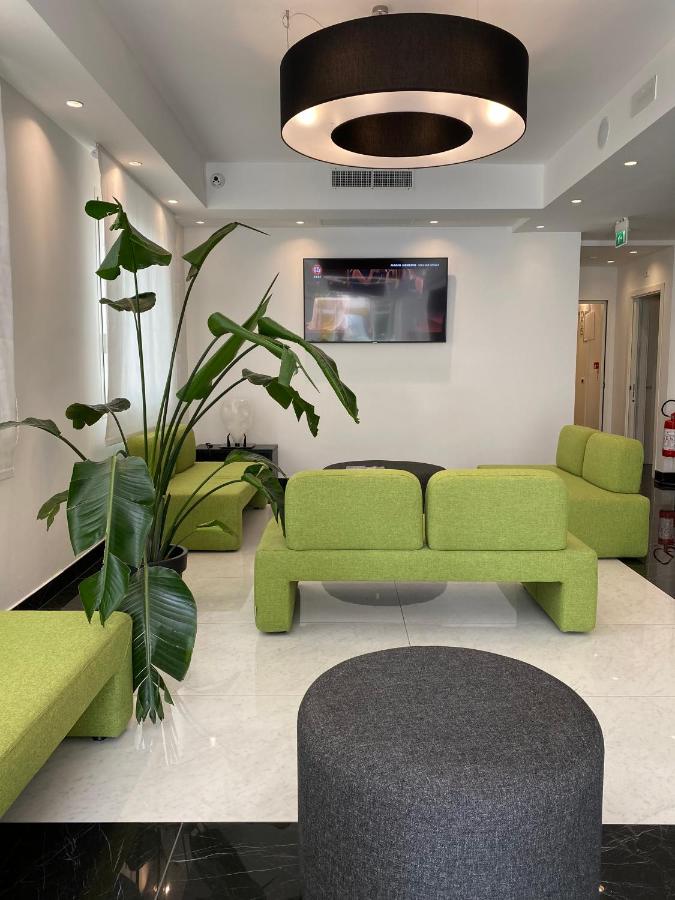 een woonkamer met een groene bank en een plant bij Hotel Ducale in Rimini