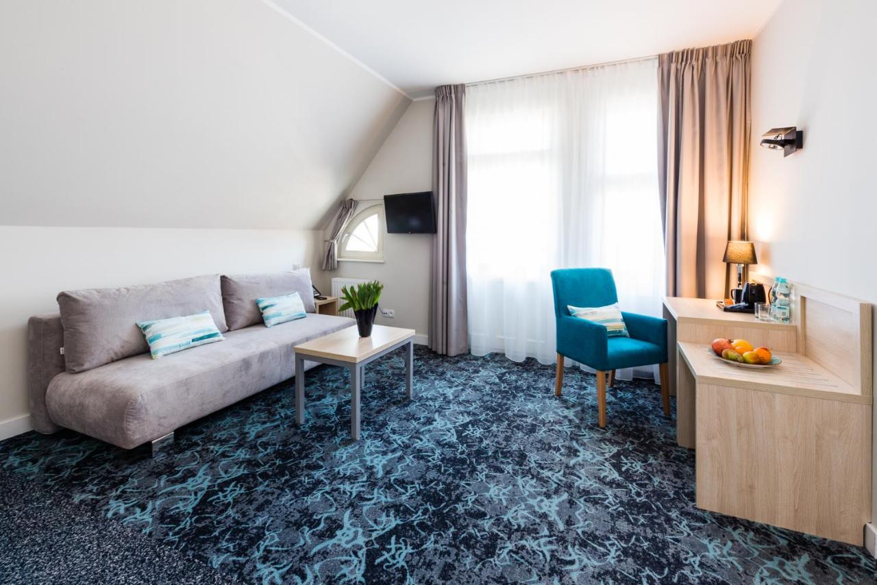 een woonkamer met een bank en een tafel bij Hotel Eureka in Sopot