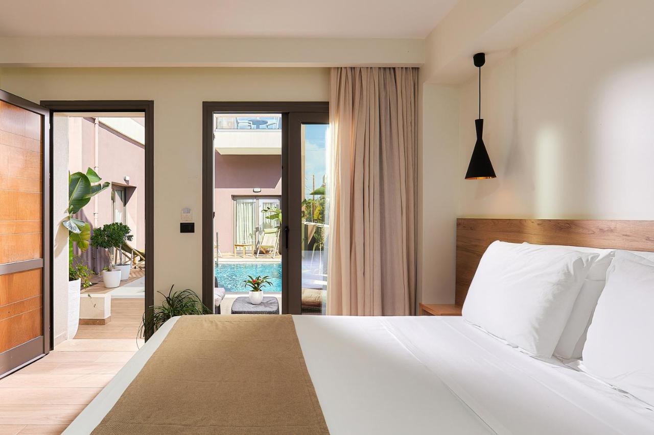 een slaapkamer met een wit bed en een balkon bij Dionisos Hotel in Malia