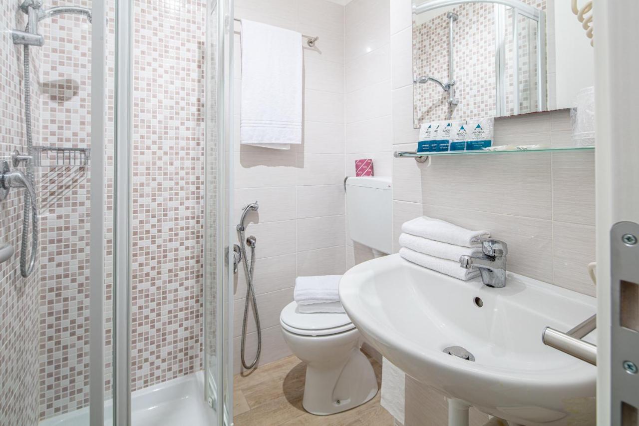 een badkamer met een toilet, een wastafel en een douche bij Hotel Pigalle in Lido di Jesolo