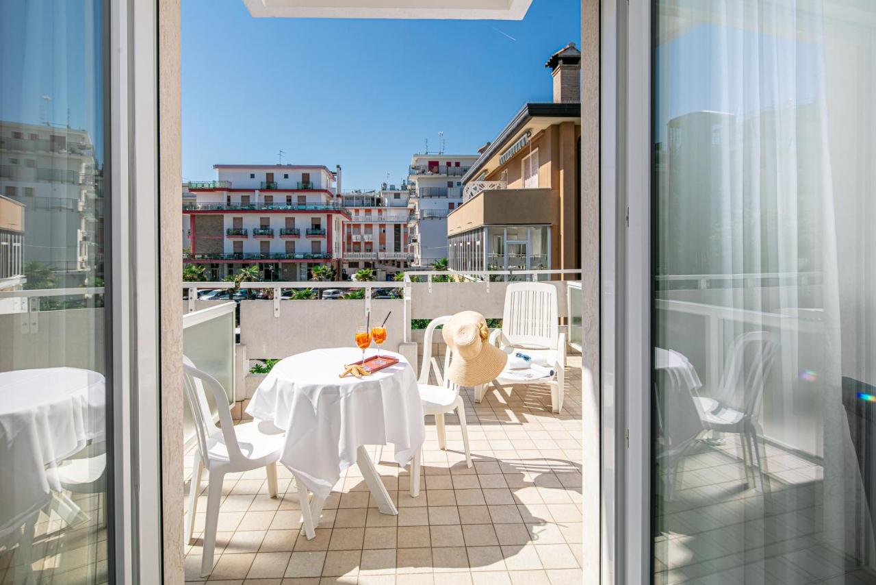 een balkon met een tafel en stoelen op een balkon bij Hotel Pigalle in Lido di Jesolo