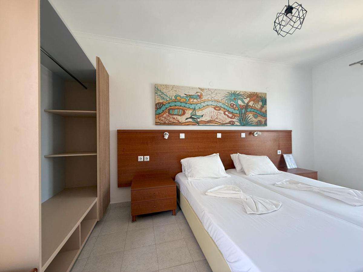 een slaapkamer met twee bedden en een kledingkast bij Elga Hotel & apartments in Kardamaina