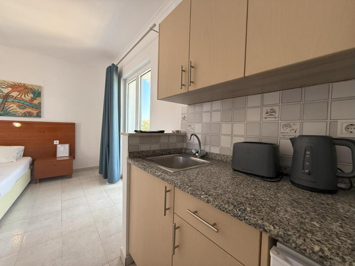 een keuken met een gootsteen en een bed in een kamer bij Elga Hotel & apartments in Kardamaina
