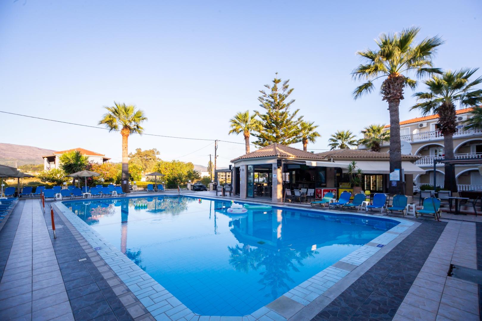 Buitenzwembad met ligbedden — Vivian Hotel