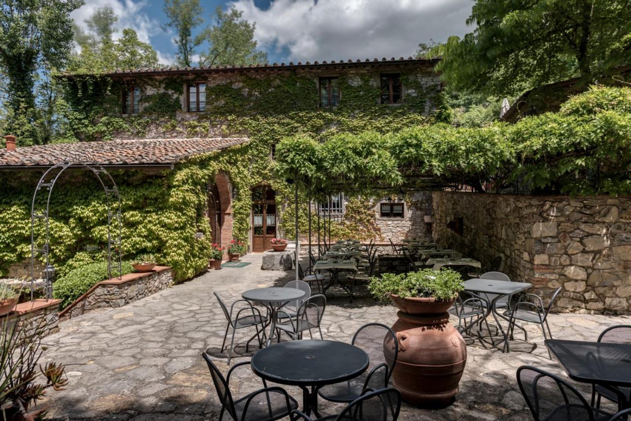 een terras met tafels en stoelen voor een gebouw bij Ultimo Mulino Country Hotel in Gaiole in Chianti