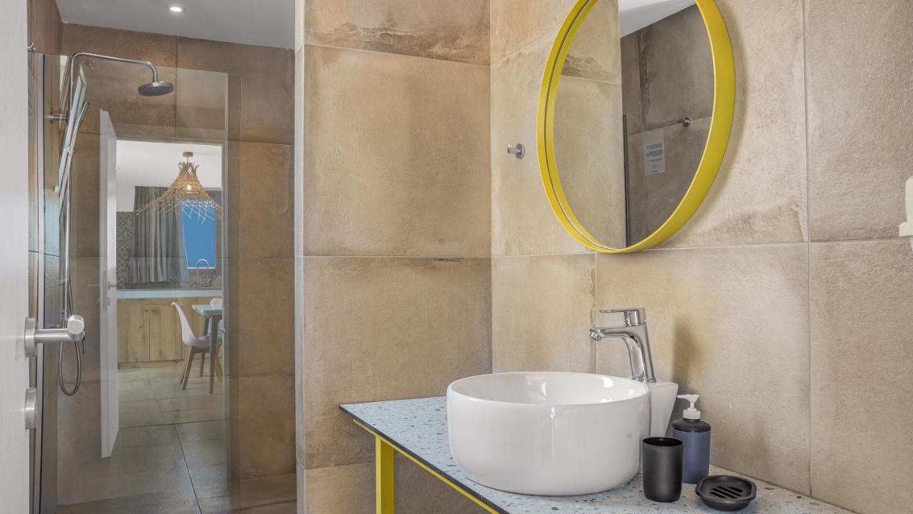 een badkamer met een wastafel en een spiegel bij Natali Apartments by Estia in Malia