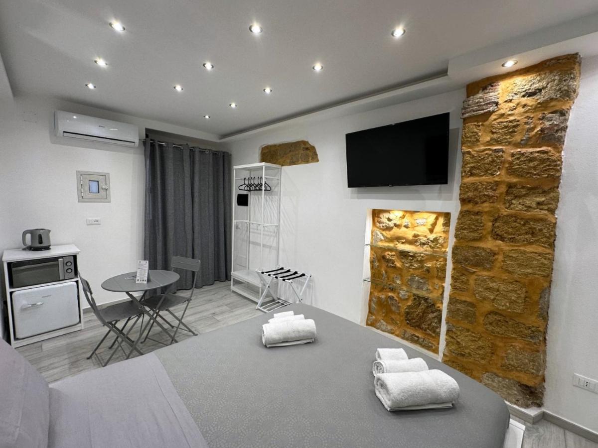 een woonkamer met een stenen muur en een tv bij Ó sole mio in Palermo