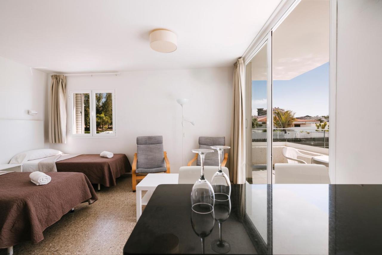 een woonkamer met een tafel en een balkon bij Apartamentos LIVVO Tarahal in San Agustin