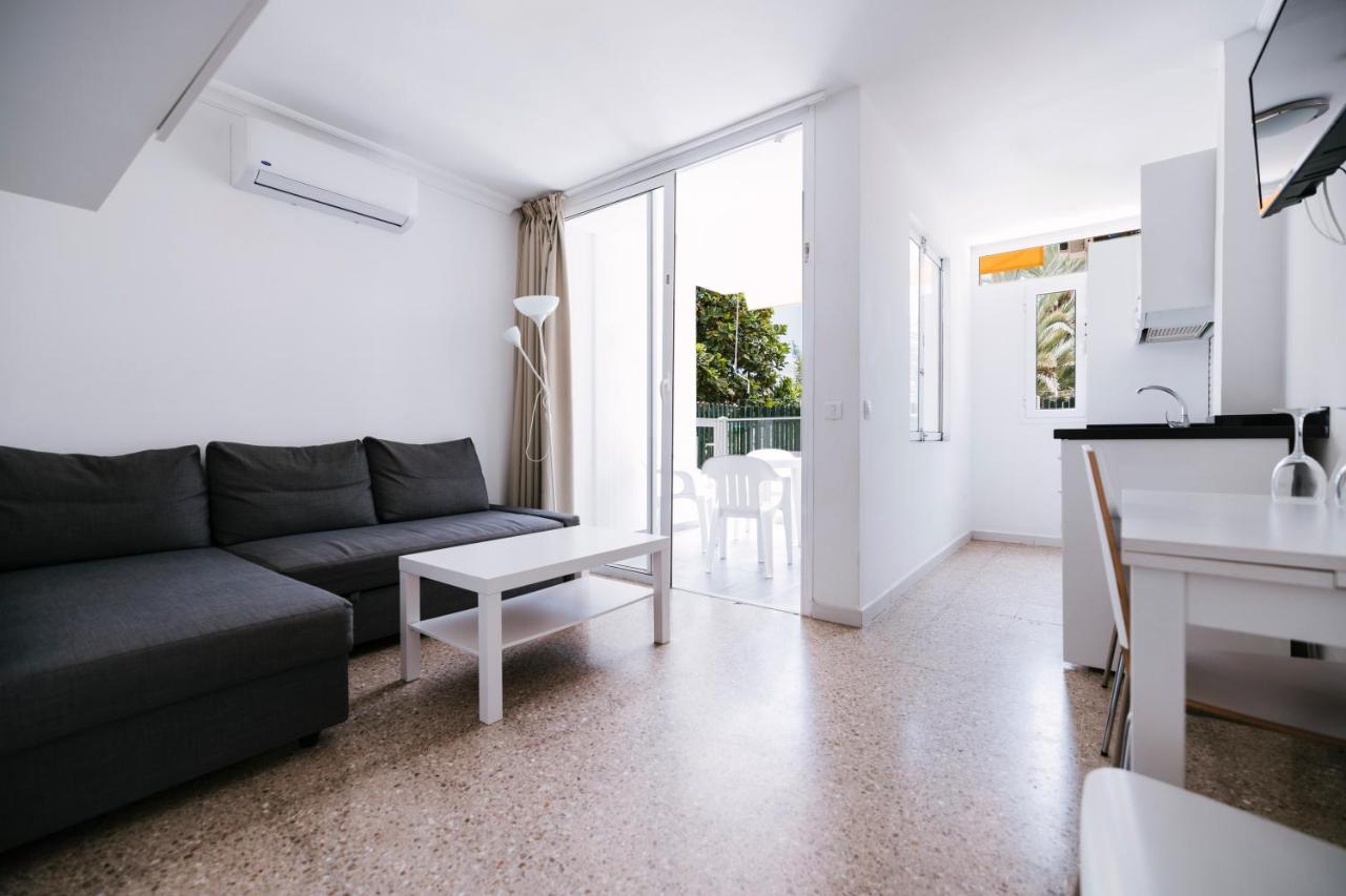 een woonkamer met een bank en een tafel bij Apartamentos LIVVO Tarahal in San Agustin