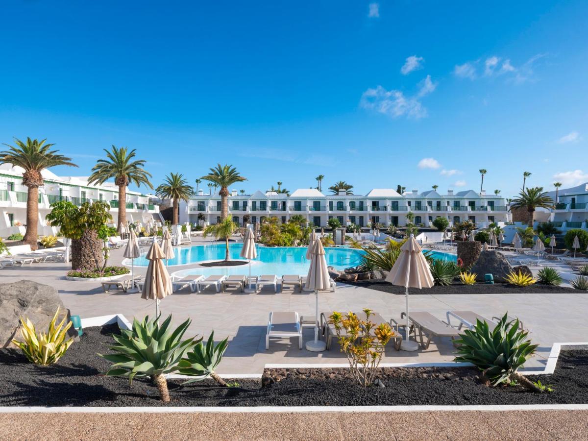 een resort met een zwembad en palmbomen bij MYND Yaiza in Playa Blanca