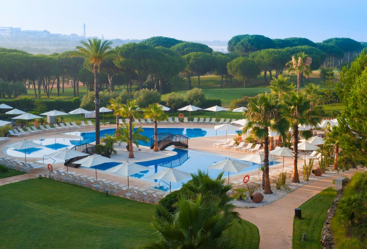 een luchtfoto van een zwembad van een resort met palmbomen bij Precise Resort El Rompido-The Hotel in El Rompido