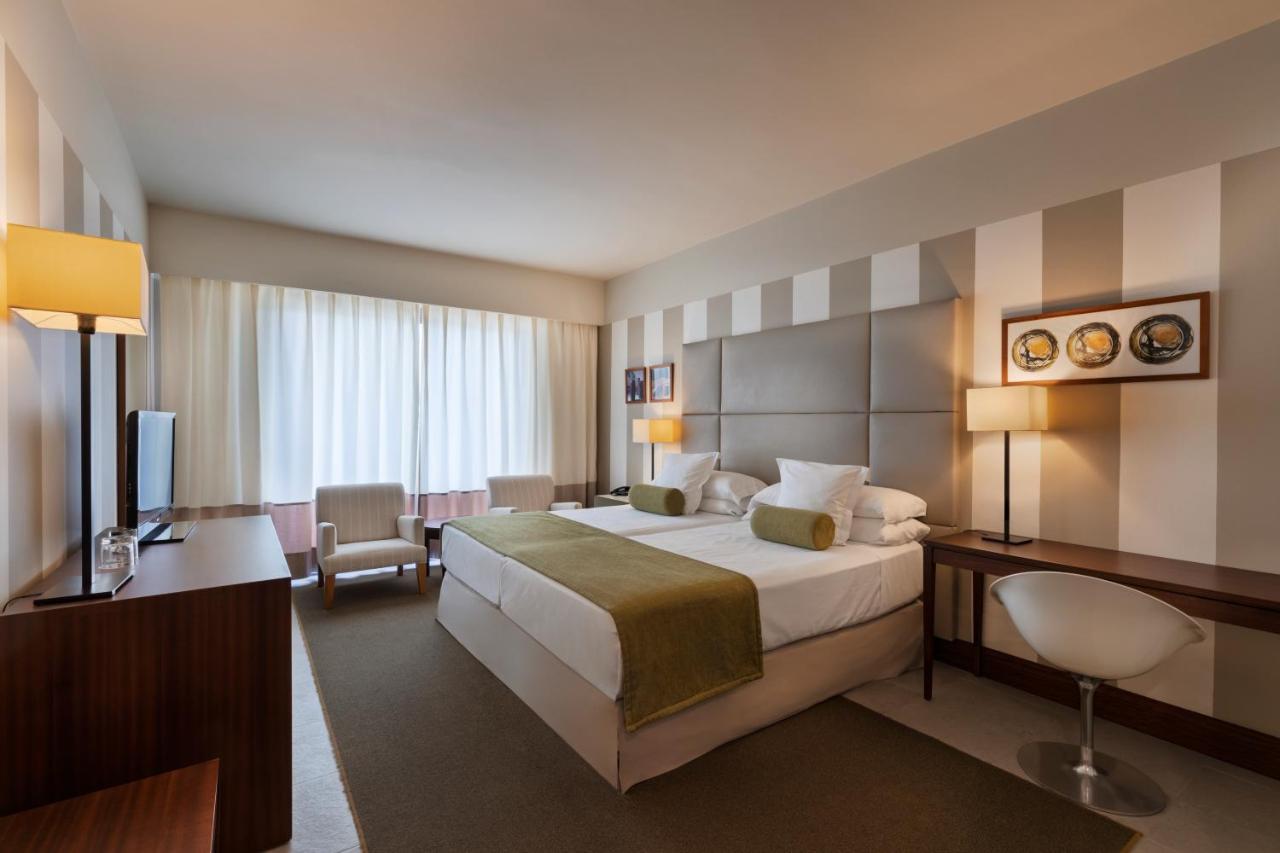 een hotelkamer met een groot bed en een bureau bij Precise Resort El Rompido-The Hotel in El Rompido