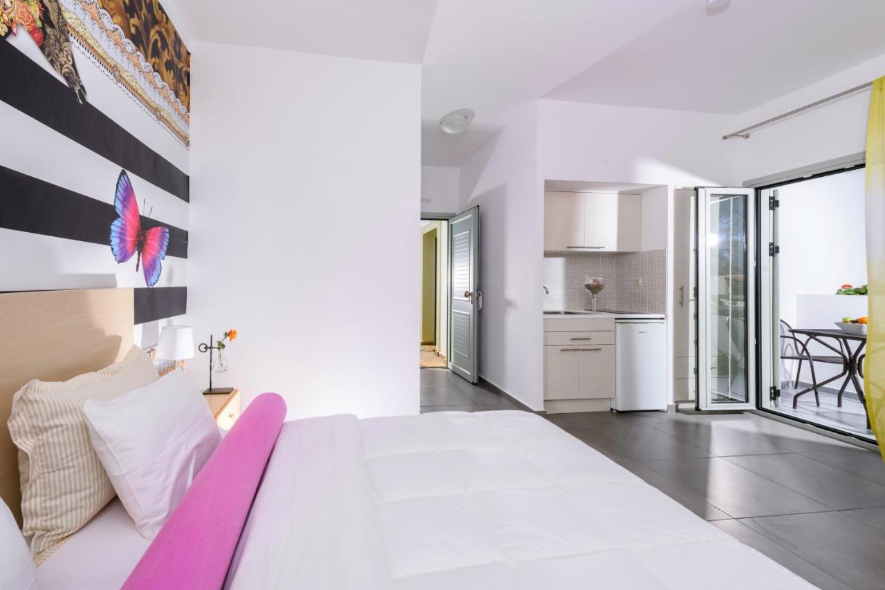 een witte slaapkamer met een groot bed en een keuken bij Angela Studios Apartments in Sissi