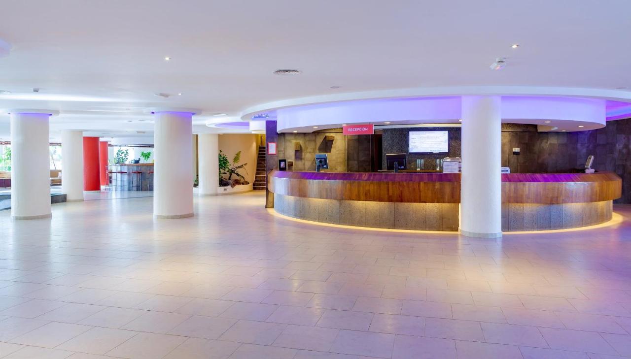 een hotellobby met zuilen en een bar bij SOL by Meliá Lanzarote All Inclusive in Puerto del Carmen