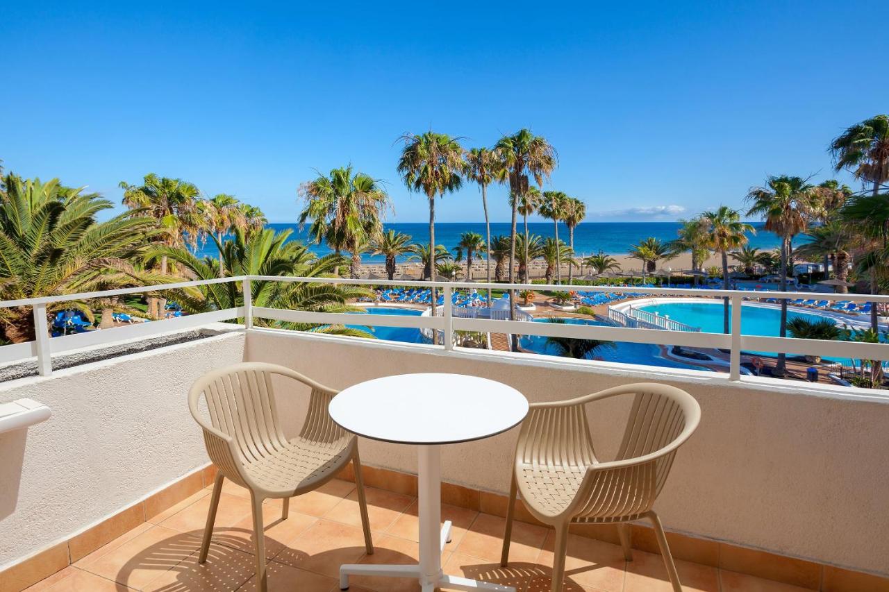 Een tafel en stoelen op een balkon met uitzicht op de oceaan. bij SOL by Meliá Lanzarote All Inclusive in Puerto del Car