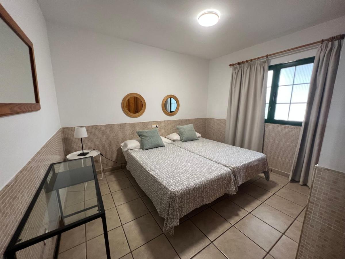een slaapkamer met een bed en een glazen tafel bij Apartamentos Acuario Sol in Puerto del Carmen
