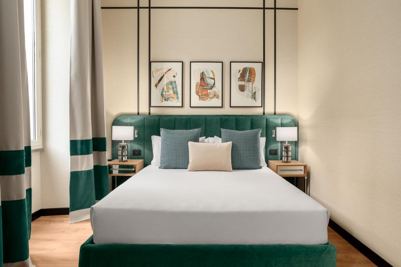 een slaapkamer met een groot bed met een groen hoofdeinde bij Room Mate Collection Mia, Rome Colosseum in Rome