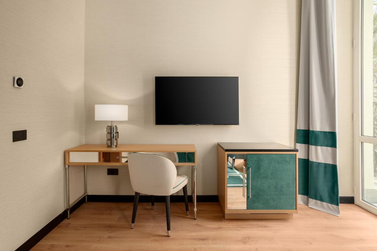 een kamer met een bureau met een stoel en een televisie bij Room Mate Collection Mia, Rome Colosseum in Rome
