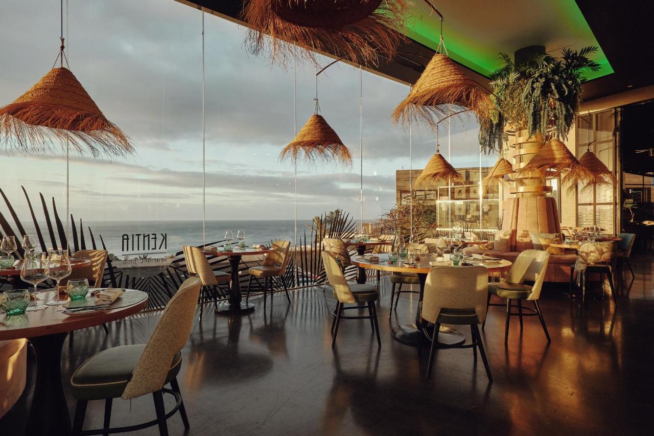 een restaurant met tafels en stoelen en een groot raam bij La Isla y el Mar, Hotel Boutique in Puerto del Carmen