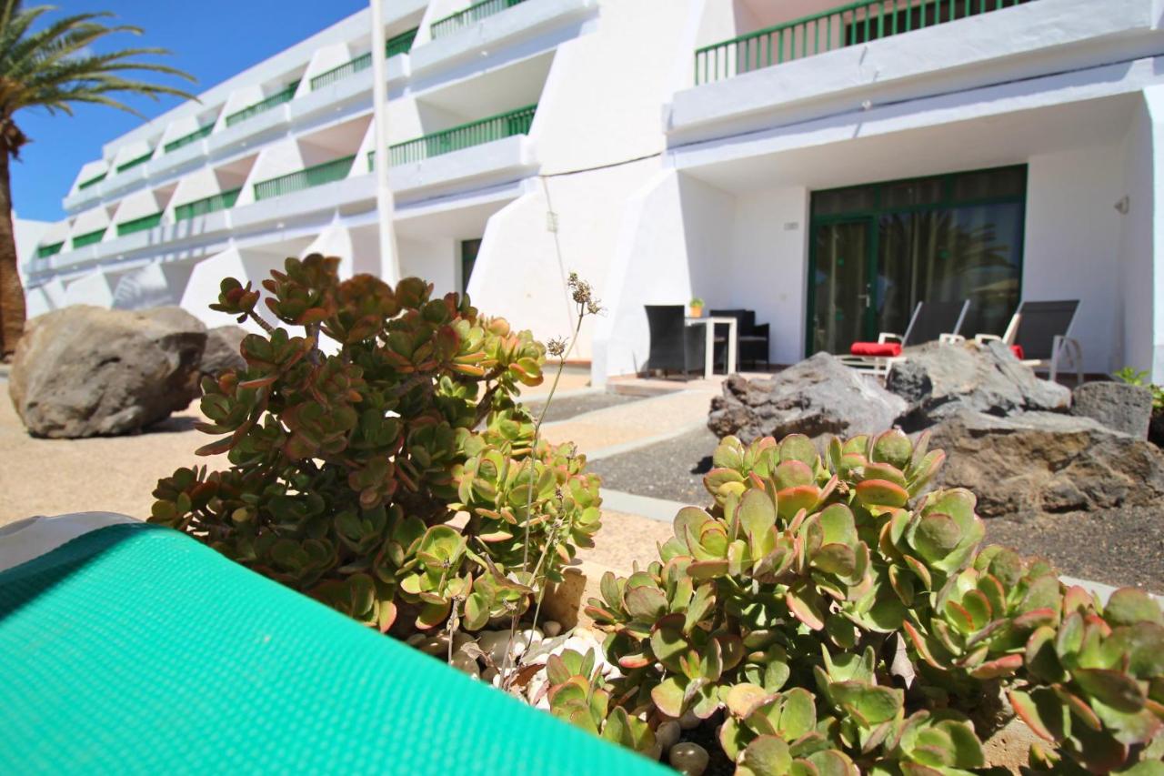 een gebouw met een struik ervoor bij Apartamentos La Peñita in Puerto del Carmen