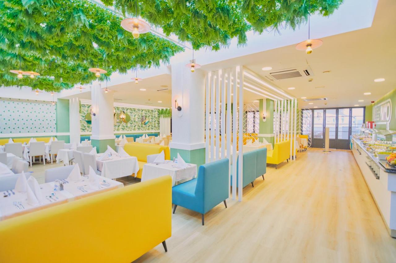 een restaurant met witte tafels en gele stoelen bij Gloria Izaro Club Hotel in Puerto del Carmen