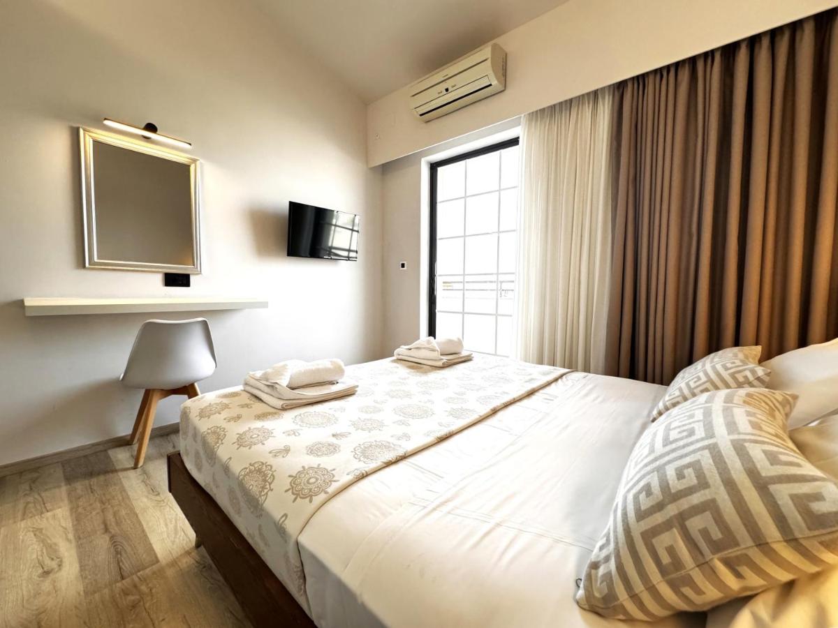een slaapkamer met een groot bed en een tv aan de muur bij Elina Hotel Apartments in Rethimnon
