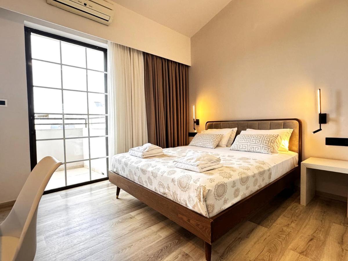 een slaapkamer met een bed en een groot raam bij Elina Hotel Apartments in Rethimnon