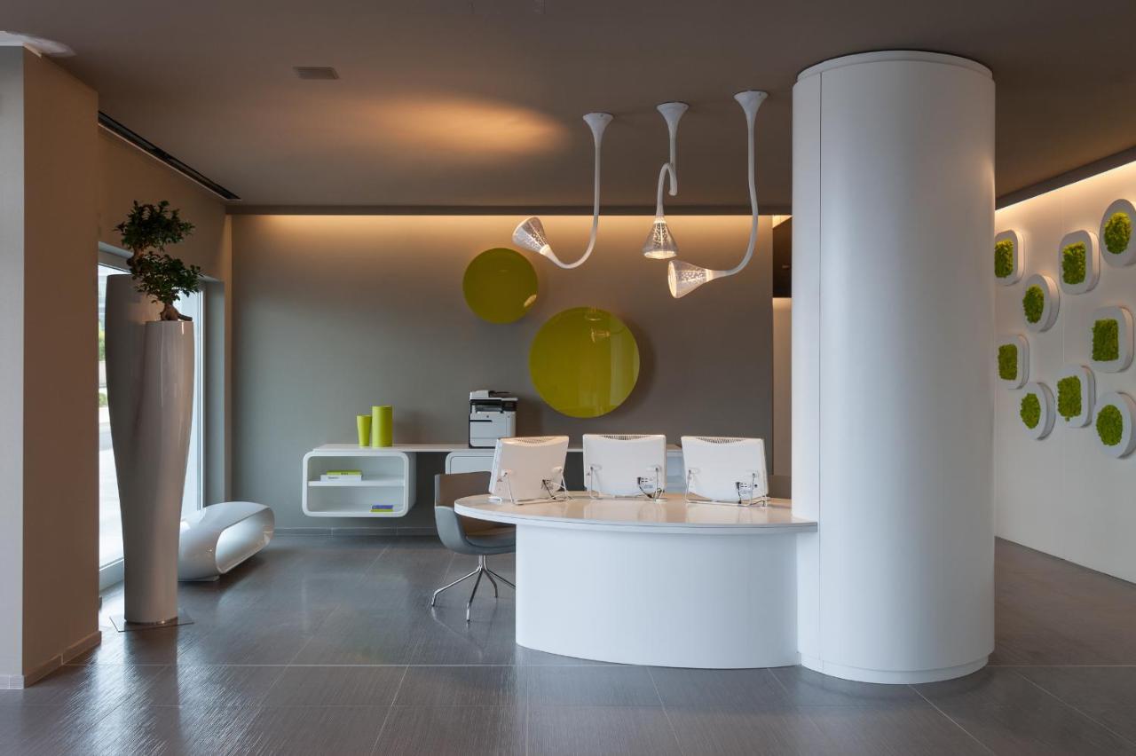 een keuken met een tafel en groene borden aan de muur bij 8Piuhotel in Lecce