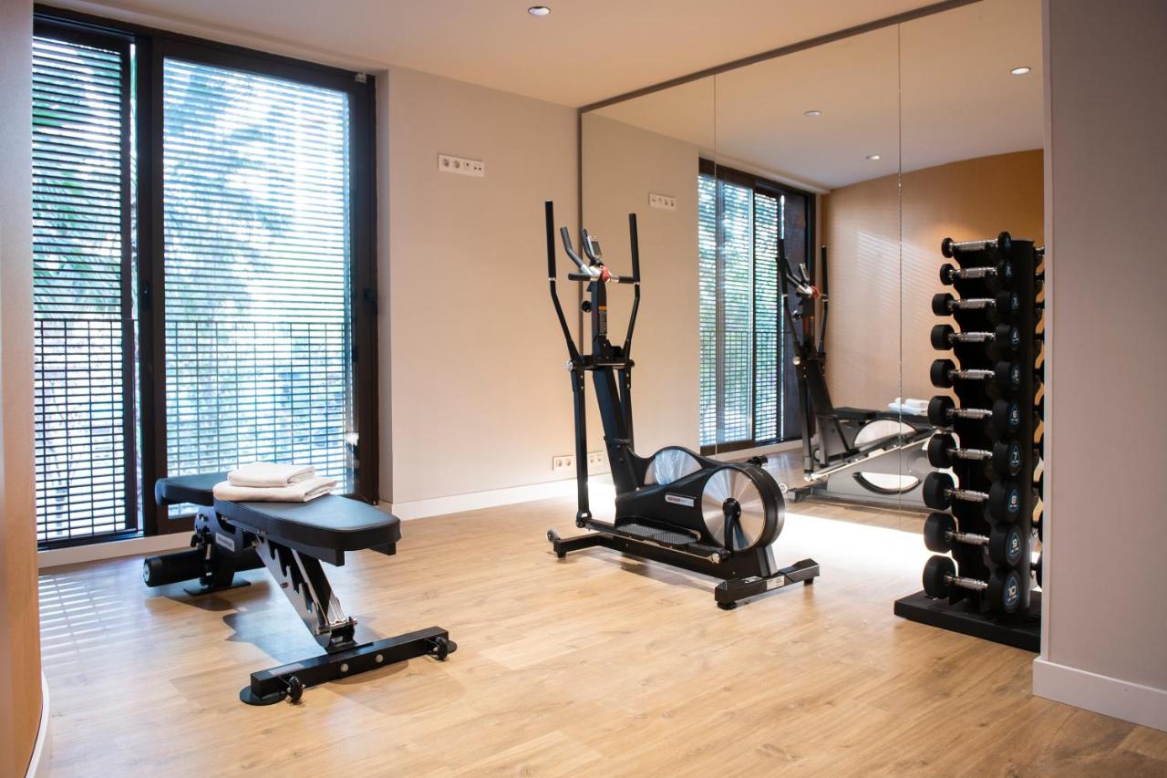 een sportschool met twee hometrainers en een spiegel bij MH Apartments Urban in Barcelona