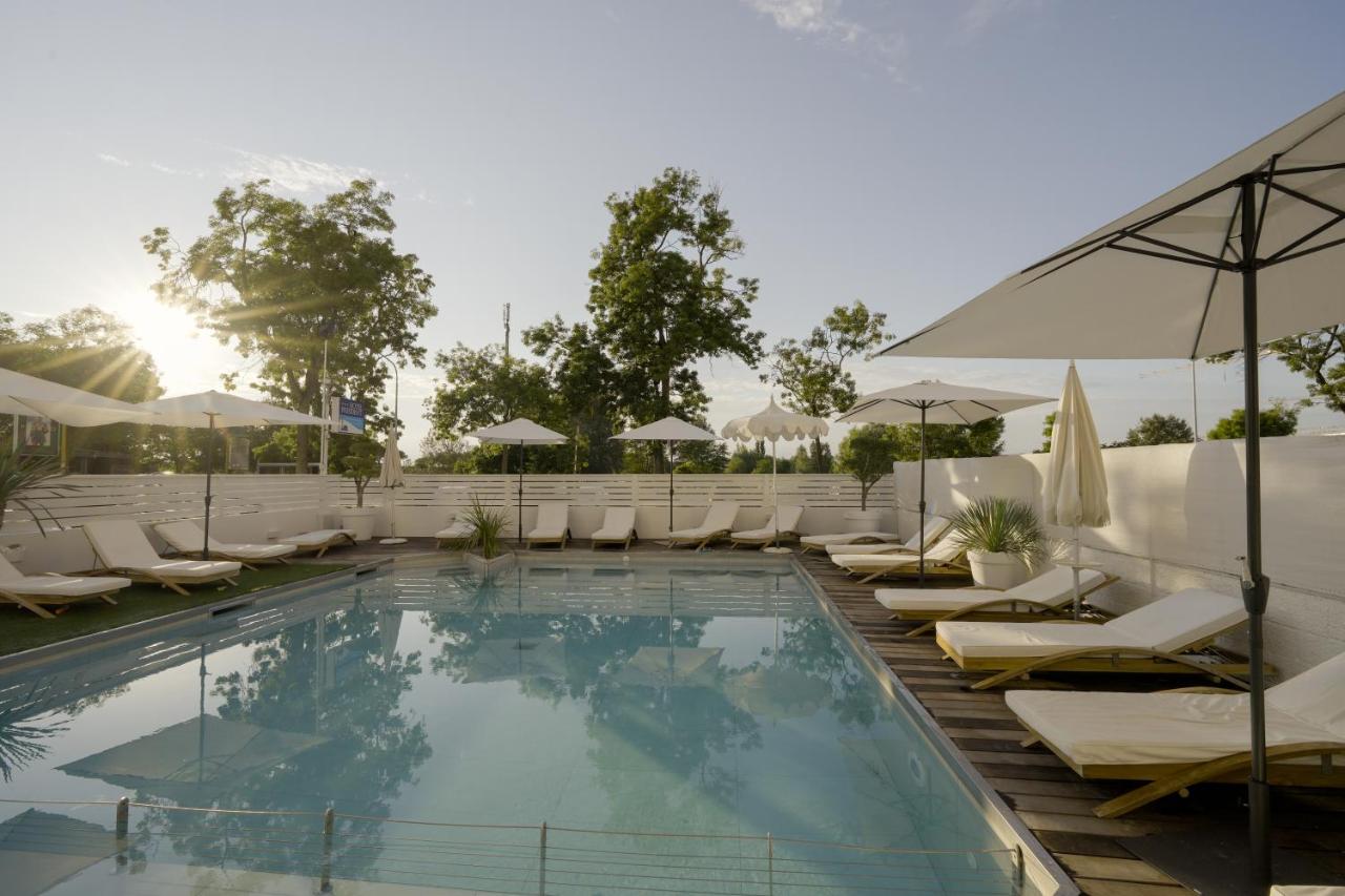 een zwembad met ligstoelen en parasols bij een hotel bij Hotel President in Lido di Jesolo