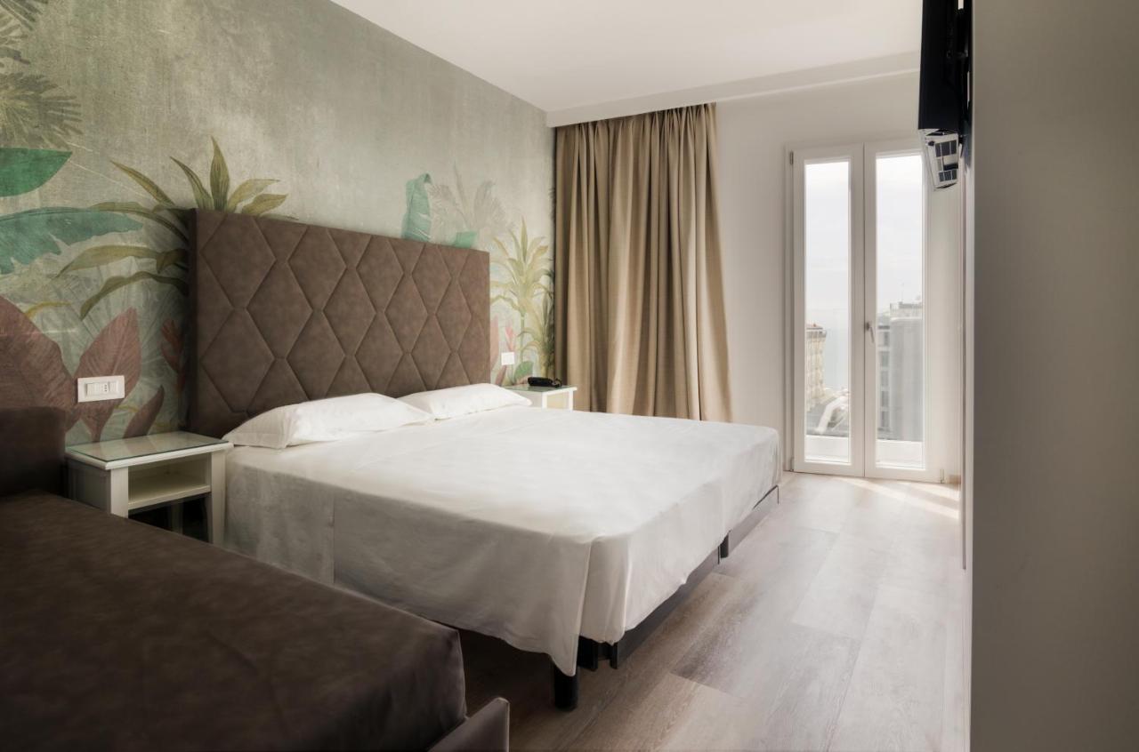 een slaapkamer met een groot wit bed en een raam bij Hotel President in Lido di Jesolo