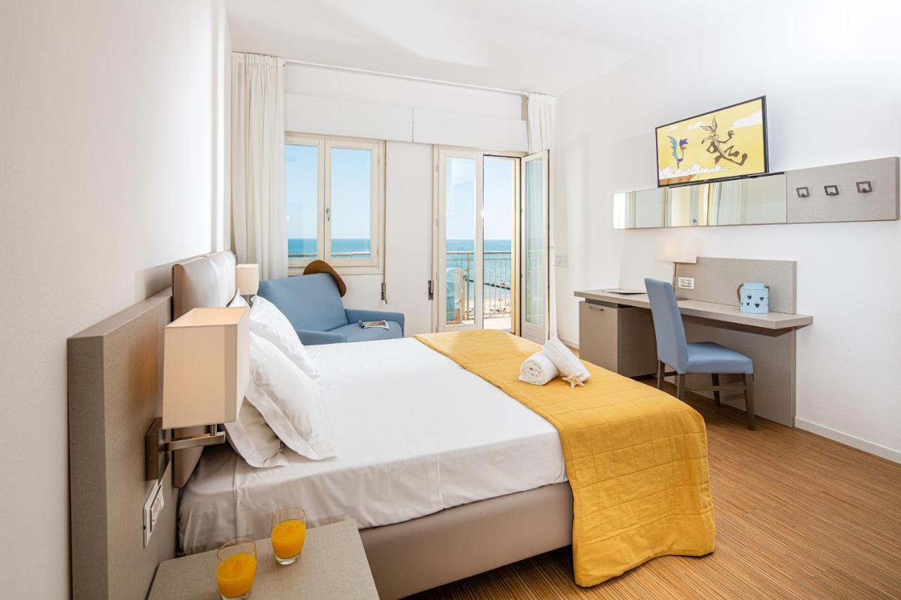een hotelkamer met een bed, een bureau en een stoel bij Hotel Astor in Lido di Jesolo