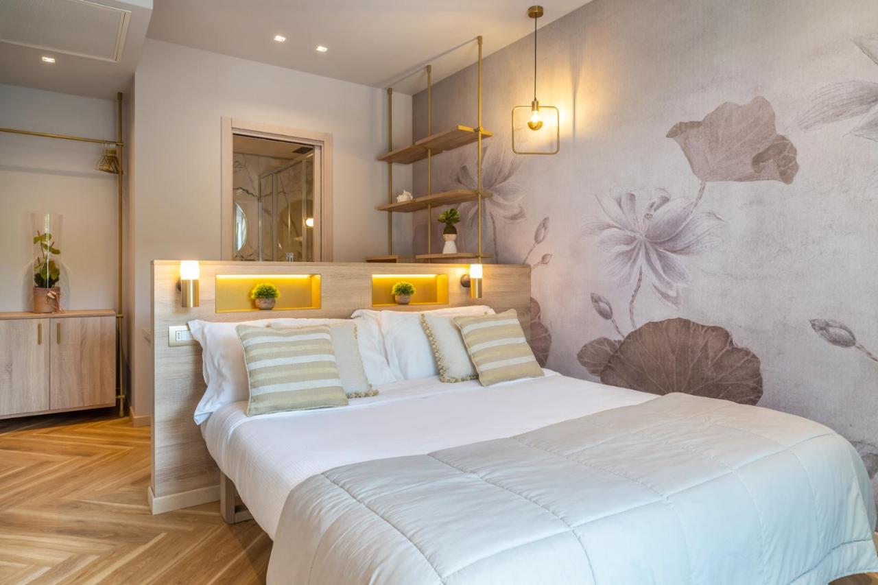 een slaapkamer met een groot wit bed in een kamer bij Salus Smart & Chic Hotel in Lido di Jesolo